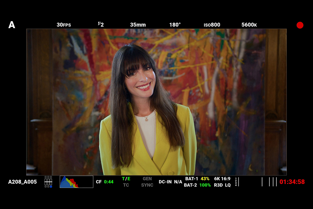 Red Digital Cinema camera monitor screenshot behind the scenes, Anne Hathaway smiling to camera.