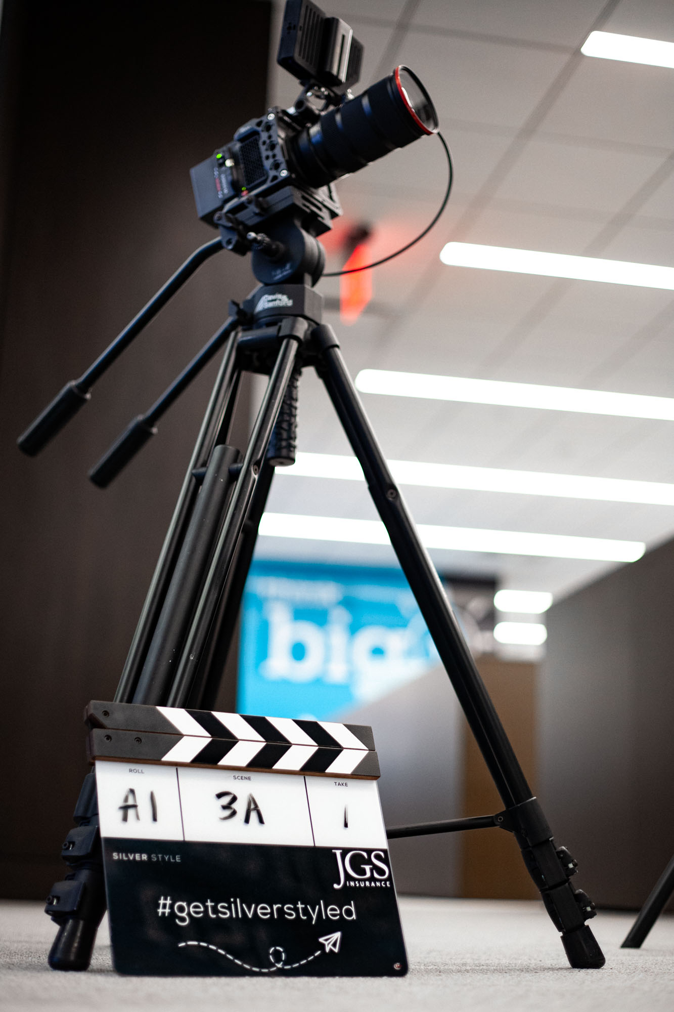 Camera and film slate on-location in for video production in corporate business office.